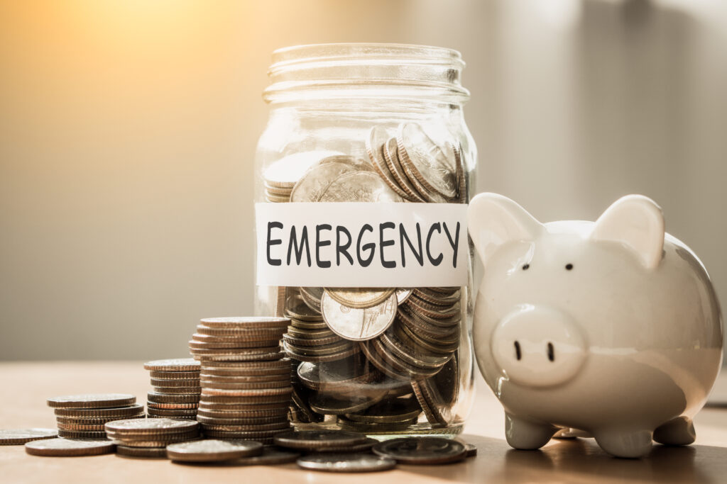 A lot coins in glass money with piggy bank for saving emergency money.Saving for emergency concept.