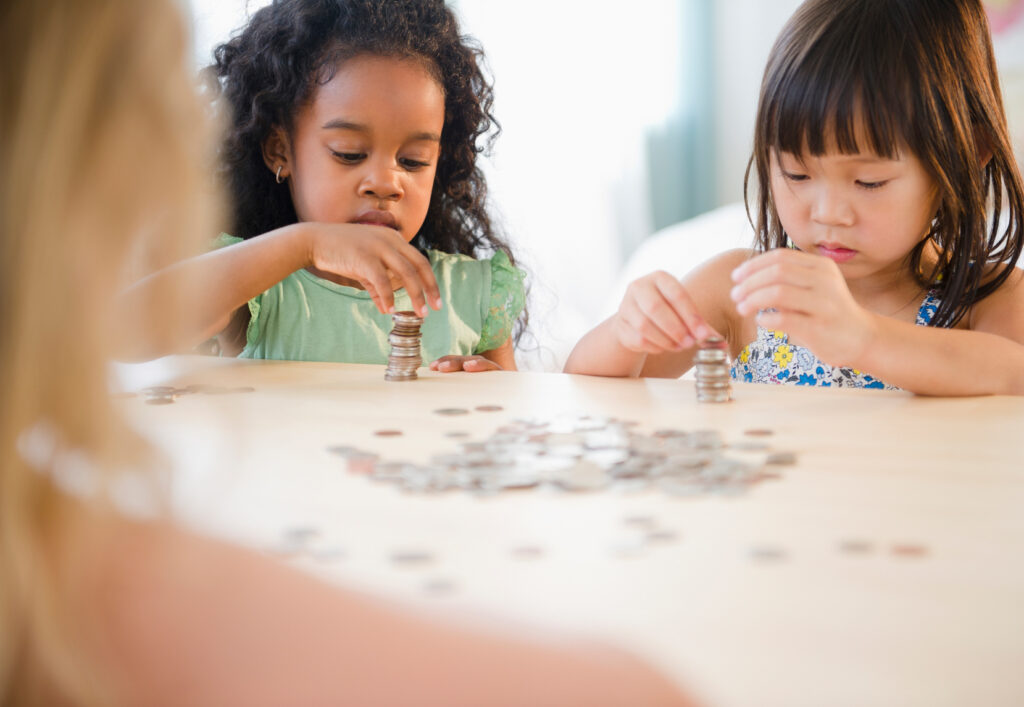 Girls stacking coins together